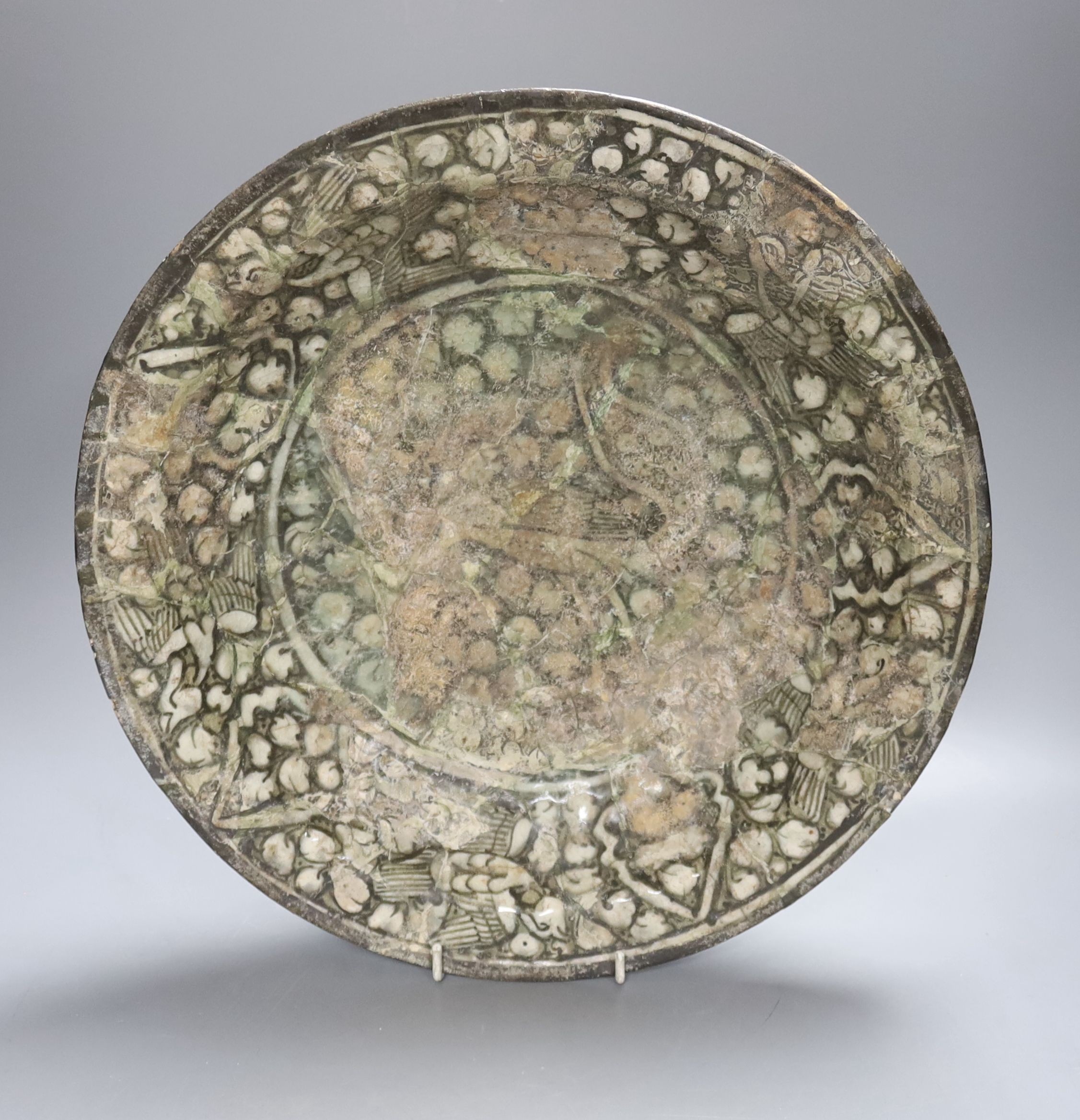 A Kashan Persian pottery dish, 13th-14th century, restored, 35 cms diameter.